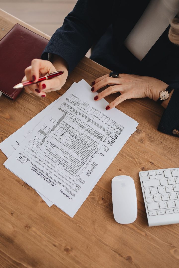 Hands preparing a U.S. tax return form on a wooden desk