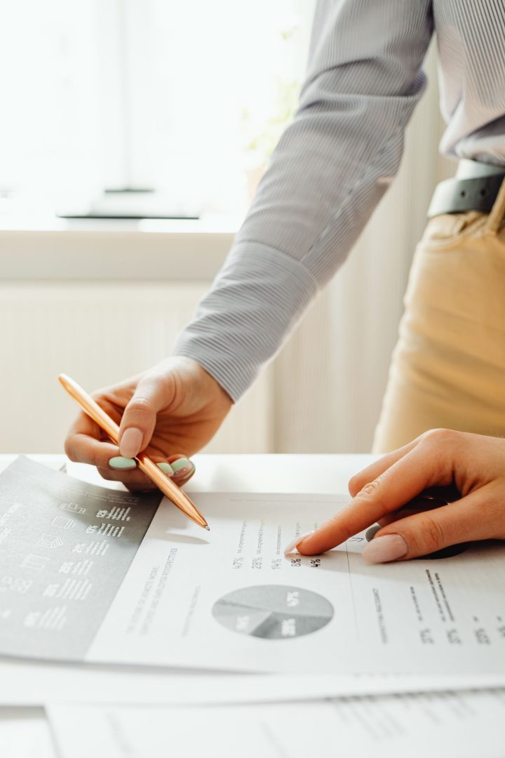 Hands pointing to figures on a printed financial report